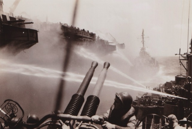 The BUNKER HILL burning, hoses played on her from the SPERRY's own 40mm mount